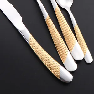 Stainless steel western cutlery set with gold textured handles, elegant steak knife and fork.