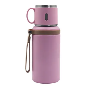 Botella de agua termica de acero inoxidable rosa con asa portatil para uso en exteriores y viajes.