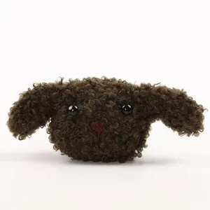 Detail van schattige bruine pluche hond, zachte donzige knuffelbedel voor tassen en accessoires.