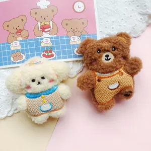 Graziosa spilla in peluche con orso marrone e cane bianco, consistenza morbida e design carino.