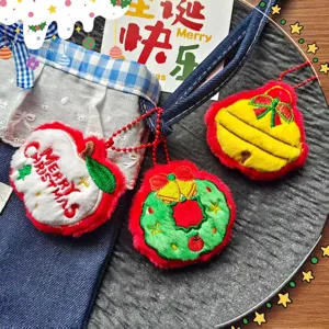 Christmas plush pendant detail showing cute embroidered apple, wreath and bell designs.