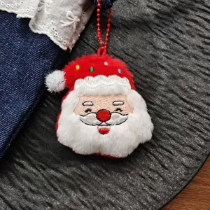Detail shot of cute Christmas Santa plush pendant with red bead chain, soft fabric decor.