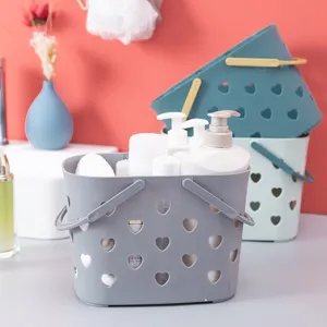 Panier de douche portable en plastique avec design ajouré en forme de cœur pour la salle de bain.