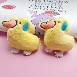 Cute yellow plush duck keychain with heart beak and blue tear, soft stuffed animal pendant.