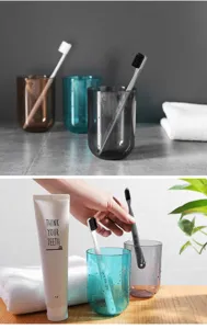 Detailansicht transparenter minimalistischer Mundbecher und Zahnbürsten im modernen Bad.