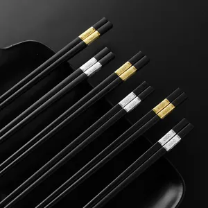 Schwarze Legierungs-Staebchen mit gold und silber Kappen, elegantes Besteck fuer den Haushalt.