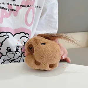 Close-up detail of cute capybara plush pendant with soft brown fur and funny long hair.