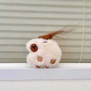Close-up detail of cute capybara plush pendant, fluffy texture with funny brown hair.