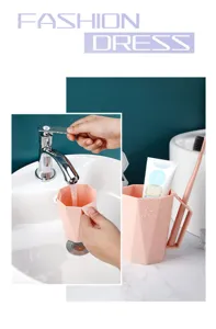 Detailed shot of pink faceted plastic toothbrush cup with handle in modern bathroom sink.