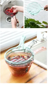 Dettaglio mestolo acqua in plastica trasparente per lavaggio cucina e irrigazione piante.