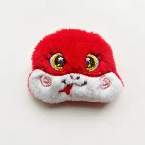 Detalle de cabeza de serpiente de peluche rojo, accesorio lindo, parche suave y esponjoso.