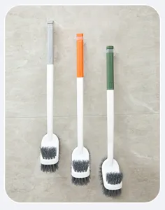 Long handled toilet brush with suction cup wall mount, plastic bathroom cleaning tool.