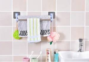 Bathroom towel holder detail view, adhesive double bar rack mounted on tiled wall setup.