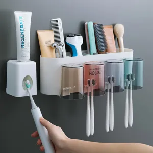 Wall mounted toothbrush holder set with automatic dispenser and cups for bathroom storage.
