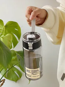 Detailansicht der klaren Kunststoff-Trinkwasserflasche mit integriertem Teesieb und Trageriemen.