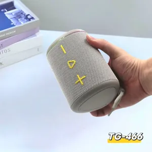 Closeup of portable bluetooth speaker with fabric mesh and yellow control buttons.