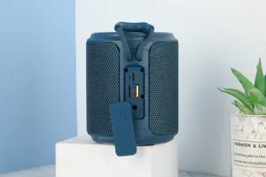 Tragbarer blauer Stoff Bluetooth Lautsprecher Detailansicht mit Audio Anschluessen und Ladeanschluss.