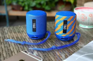 Primo piano dell'altoparlante Bluetooth cilindrico portatile con cordino per uso esterno.