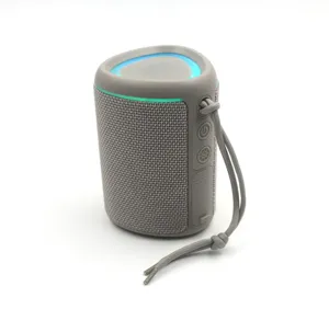 Portable fabric bluetooth speaker detail, LED glowing ring, side buttons and handy lanyard.