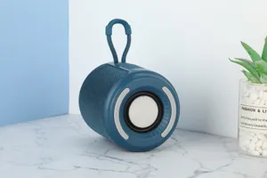 Tragbarer Outdoor Bluetooth Lautsprecher mit blauem Stoffnetz und praktischem Tragegurt.