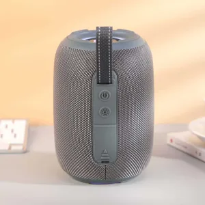 Gros plan d'une enceinte Bluetooth portable avec un tissu gris et un éclairage LED.