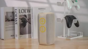 Portable cylinder bluetooth speaker with fabric mesh and yellow control buttons for outdoor.