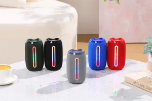 Detalle de altavoz Bluetooth cilíndrico colorido con iluminación RGB en mesa.