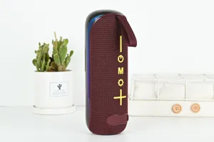 Haut-parleur Bluetooth portable en tissu élégant avec sangle de transport pratique pour l'extérieur.