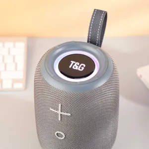 Gros plan de detail du haut-parleur Bluetooth portable gris avec un tissu maille et anneau LED.