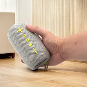 Close-up detail of the portable wireless Bluetooth speaker with stylish fabric mesh and buttons.