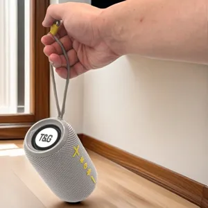 Portable waterproof bluetooth speaker detail showing grey mesh fabric body and hanging strap.