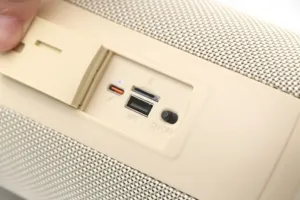 Close-up view of the portable bluetooth speaker interface, showing ports and fabric mesh.