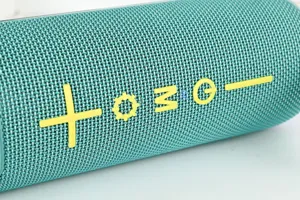 Haut-parleur Bluetooth sans fil portable avec design en tissu, corps turquoise.