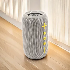 Detailed view of portable Bluetooth speaker, textured grey fabric mesh and yellow buttons.
