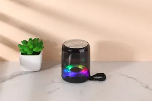 Portable wireless bluetooth speaker detail view with vibrant colorful LED lights and lanyard.