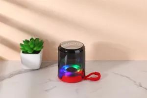Portable Bluetooth speaker with colorful LED lights and red lanyard, compact outdoor audio.