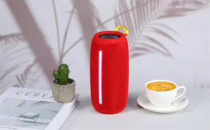 Portable wireless bluetooth speaker in vibrant red with LED light strip and convenient hook.