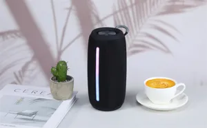 Portable black Bluetooth speaker featuring a colorful LED light strip and hanging loop.
