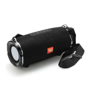 Portable black Bluetooth speaker close-up, showing fabric mesh and side radiator.