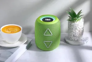 Vue détaillée de l'enceinte Bluetooth sans fil cylindrique verte avec éclairage LED.