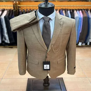 Λεπτομέρεια ανδρικού κοστουμιού slim fit μονόπετου σε καφέ χρώμα με ασορτί παντελόνι.