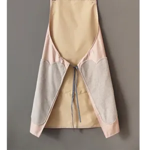 Detailed view of a waterproof kitchen apron with coral fleece hand wiping towels on both sides.