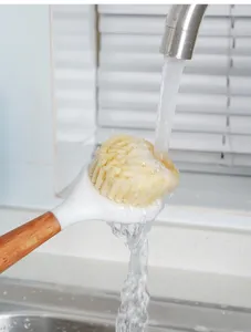 Langer Holzgriff Küchenreinigungsbürste Detail zeigt dichte Borsten unter fließendem Wasser.