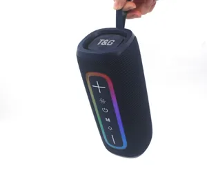 Tragbarer Bluetooth Lautsprecher mit RGB Licht, starkem Bass, dunkelblauem Stoff, Hand Detail.