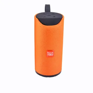Portable orange cylindrical bluetooth speaker detail showing fabric mesh and top control buttons.