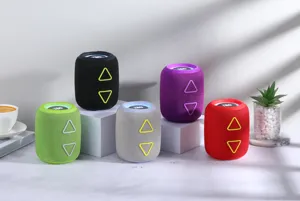 Enceinte Bluetooth sans fil cylindrique avec lumières colorées et touches de contrôle triangulaires.