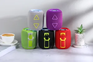 Vue détaillée de haut-parleurs Bluetooth portables colorés avec lumières RVB et sangle.