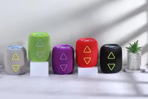 Détail d'enceinte Bluetooth cylindrique avec lumières colorées vibrantes et effet de basses.