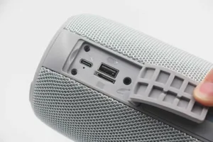 Tragbarer kabelloser Bluetooth-Lautsprecher Detailansicht mit Ladeports und Stoffbezug.