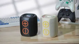 Vista dettagliata di mini altoparlanti bluetooth portatili in nero e beige con grandi tasti.